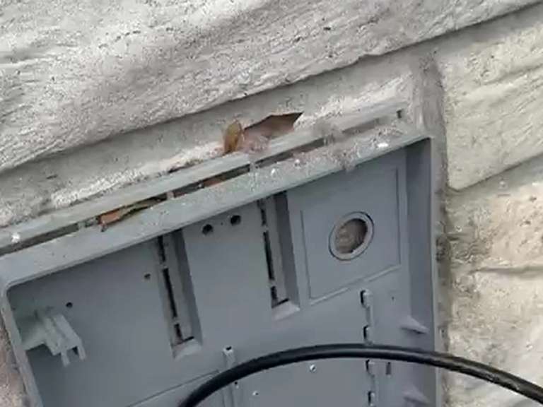 A dryer vent wall box on a stone exterior with its hood taken off, ready to be checked