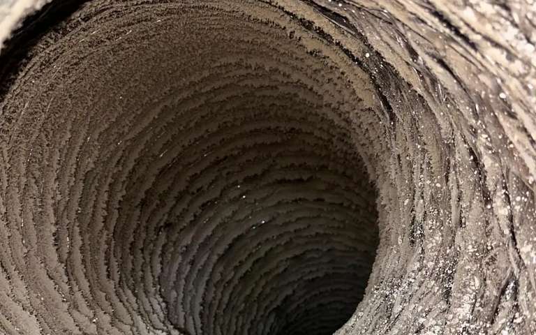 Inside a flexible duct run caked with lint, the kind that is past cleaning