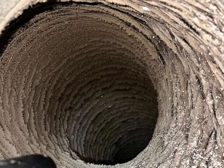 Inside a flexible duct run caked with lint, the kind that is past cleaning