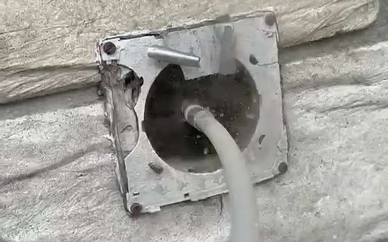 Ecovent footage: the rotary brush working through a dryer vent from the exterior hood on a stone wall