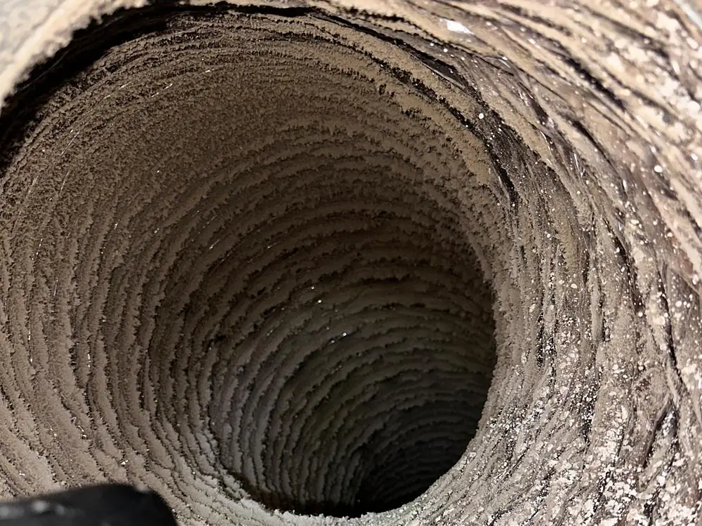 Inside a flexible duct run caked with lint, the kind that is past cleaning